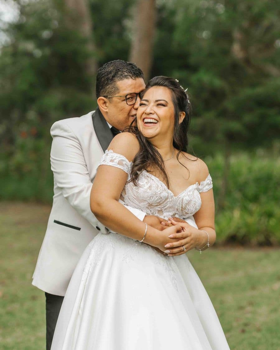 Groom kissing his bride outdoors — documentary wedding photographer